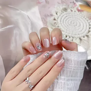 Handmade short cat-eye press-on nails in pale pink with diamond butterfly accents