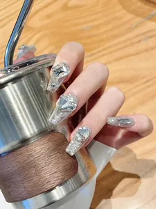 Detail of long coffin press-on nails with silver glitter, rhinestones and pearls