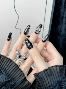 Detail of handmade black coffin press-on nails with silver butterfly and glitter accents