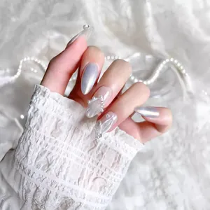 Silver cat-eye press-on nails with 3D pearls and rhinestone wing accents on lace background