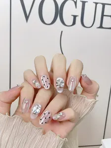 Detail of pink cat-eye press-on nails with sparkling rhinestones and silver metal edges