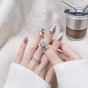 Faux ongles œil de chat champagne avec strass de luxe et cristaux gris forme cercueil long