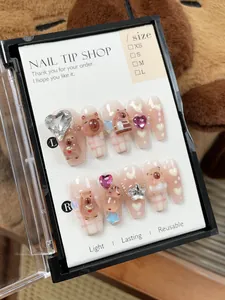 Detailed look at handmade pink gradient press-on nails with 3D bears and heart gems