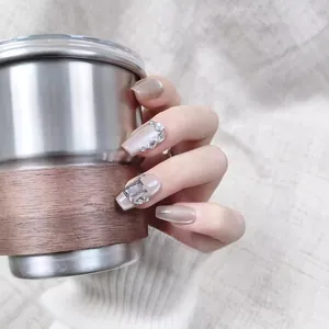 Faux ongles rose nude scintillant avec strass de luxe et accents en métal argenté