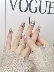 Detailed view of nude pink cat-eye press-on nails with sparkling rhinestones and pearls