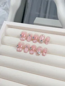 Macro shot of 10-piece handmade pink gradient press-on nails with 3D butterfly charms