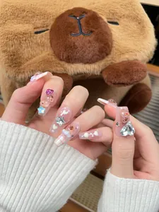 Detail of pink French press-on nails with 3D teddy bear and heart rhinestone decorations