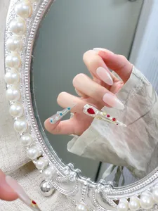 Detail von Stiletto-Nägeln mit Rubin-, Saphir- und Perlenverzierungen im Vintage-Stil