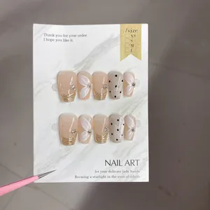 Détails macro d'ongles faits main avec motifs floraux, lignes dorées et pois noirs