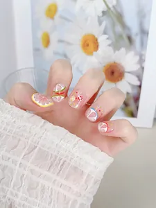 Vista detallada de uñas postizas de verano con limones y frutas en una modelo