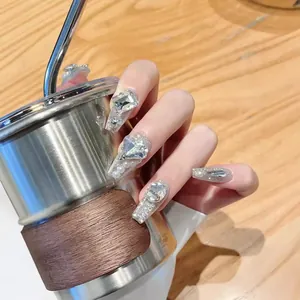Sparkling silver glitter press-on nails with luxury rhinestones and pearls on a long coffin shape