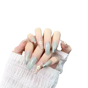 Green cat eye press-on nails in long coffin shape with French tips and 3D floral accents