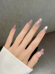 Detailed view of long coffin press-on nails with pink gradient and white butterfly art