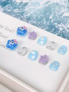 Detail of 3D sea-themed handmade press-on nails with blue cartoon creature and stars
