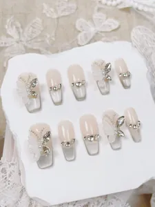 Detalle de uñas postizas hechas a mano con mariposas 3D, diamantes y degradado suave