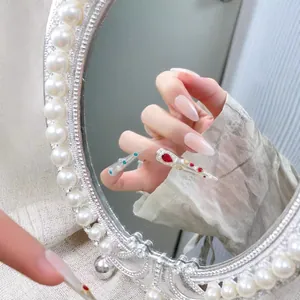 Luxuriöse Stiletto-Nägel mit roten Strasssteinen und Perlen im Vintage-Palast-Stil