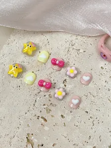 Detail of cute handmade cartoon press-on nails for girls with stars and bows