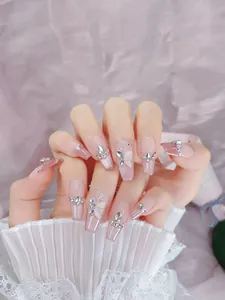 Detail of pink gradient press-on nails with 3D white butterfly and silver rhinestones
