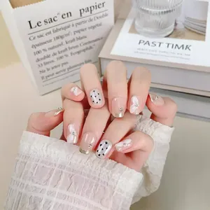 Faux ongles faits main avec nœuds 3D blancs, pois noirs et pointes françaises pailletées
