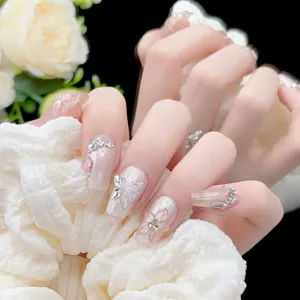 Handmade press-on nails with pink cat-eye glitter, 3D butterfly, and floral rhinestone design