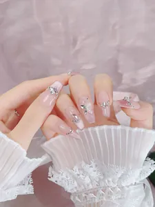 Detail of pink cat eye press-on nails with silver butterflies and rhinestones