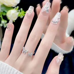 Elegant handmade press-on nails featuring butterfly ring and floral crystal accents