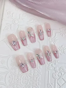 Detailed view of pink ombre coffin press-on nails with 3D butterfly and rhinestone accents