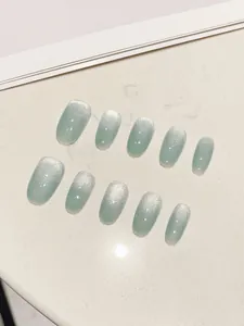 Λεπτομέρεια χειροποίητων πράσινων cat-eye νυχιών με ασημί γκλίτερ και εφέ διαβάθμισης