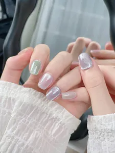 Detail of colorful cat-eye press-on nails with glitter finish and mirror reflection
