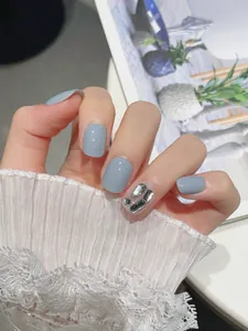 Close-up of handmade dusty blue press-on nails with silver rhinestone diamond accents