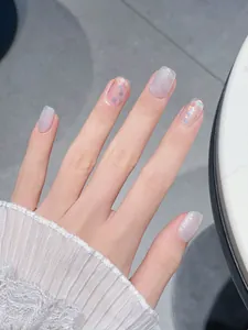 Detail view of square sparkling cat-eye press-on nails with silver glitter and sequins