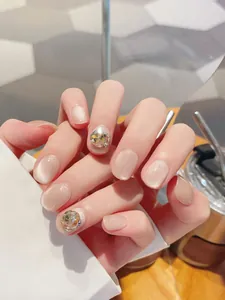 Macro detail of handmade cat eye press-on nails with golden magnetic shimmer and rhinestones