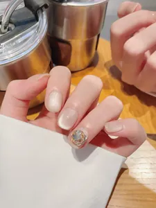 Macro shot of handmade champagne cat eye press-on nails with large gemstone accent