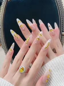 Détails de faux ongles longs en amande avec paillettes papillon jaunes et strass brillants