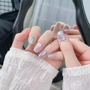 Handmade cat-eye press-on nails in pastel colors with glitter effect and light reflection