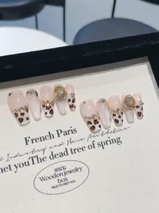 Détail de faux ongles léopard forme cercueil avec strass de couleur champagne