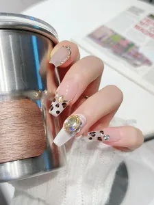 Détail de faux ongles longs ballerine avec motifs léopard et strass champagne