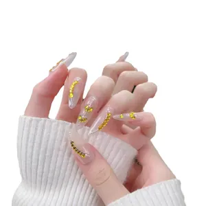 Faux ongles amande faits main avec strass cœur jaunes et détails en feuille d'or