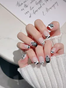 Gros plan d'ongles à presser avec fleurs 3D, pois et strass sur une base rose poudré