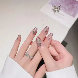 Pink cat-eye press-on nails with silver butterfly charms and matching sparkle ring