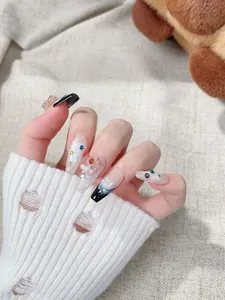 Detalle de uñas postizas hechas a mano con ositos 3D, perlas y pedrería fina