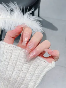 Macro detail of coffin press-on nails with pink base, 3D butterfly, and pearl accents