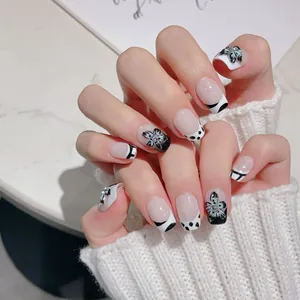 Faux ongles faits main avec fleurs 3D noires et blanches, pois et French tips