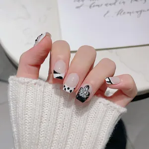 Faux ongles faits main noir et blanc avec fleurs 3D et accents de strass