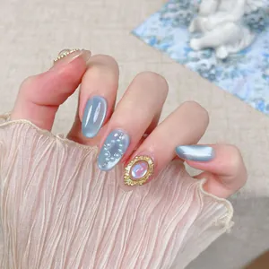 Faux ongles bleus faits main effet œil de chat avec perles et cristaux pour brillance
