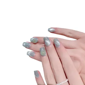Handmade silver cat-eye press-on nails with green accents and gold bow charms