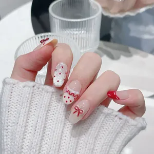 Unghie finte fatte a mano con fiocchi rossi, pois e glitter argento su base bianca