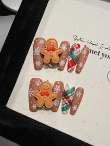 Détail de faux ongles de Noël avec bonhomme de pain d'épices 3D et motifs flocons