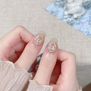 Faux ongles dorés faits main avec cadres en relief et perles irisées élégantes
