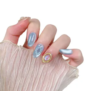 Faux ongles faits main bleu clair œil de chat avec bijoux dorés et perles blanches